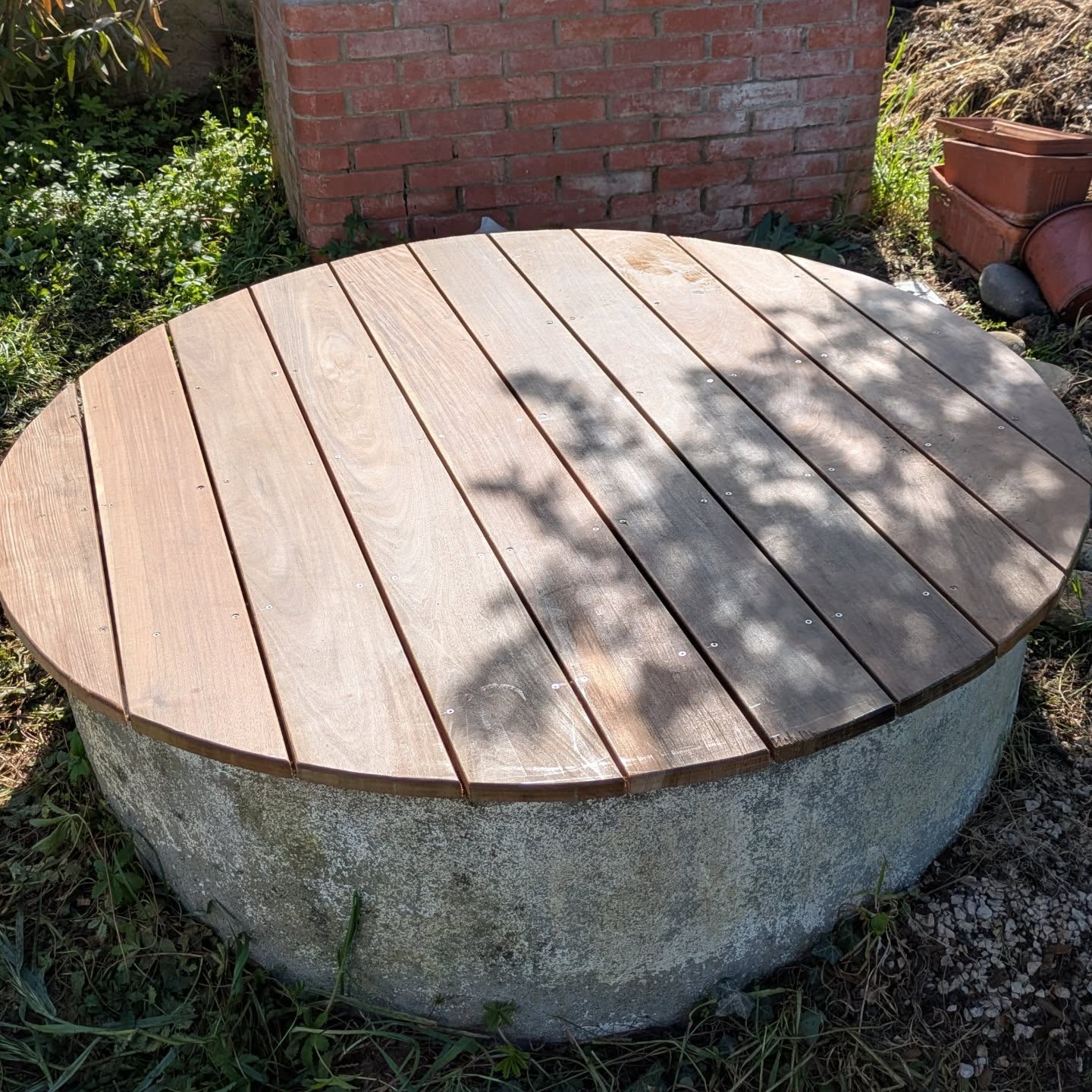Terrasse en bois d’ipé conçue pour couvrir et sécuriser l’ouverture d’un puits.